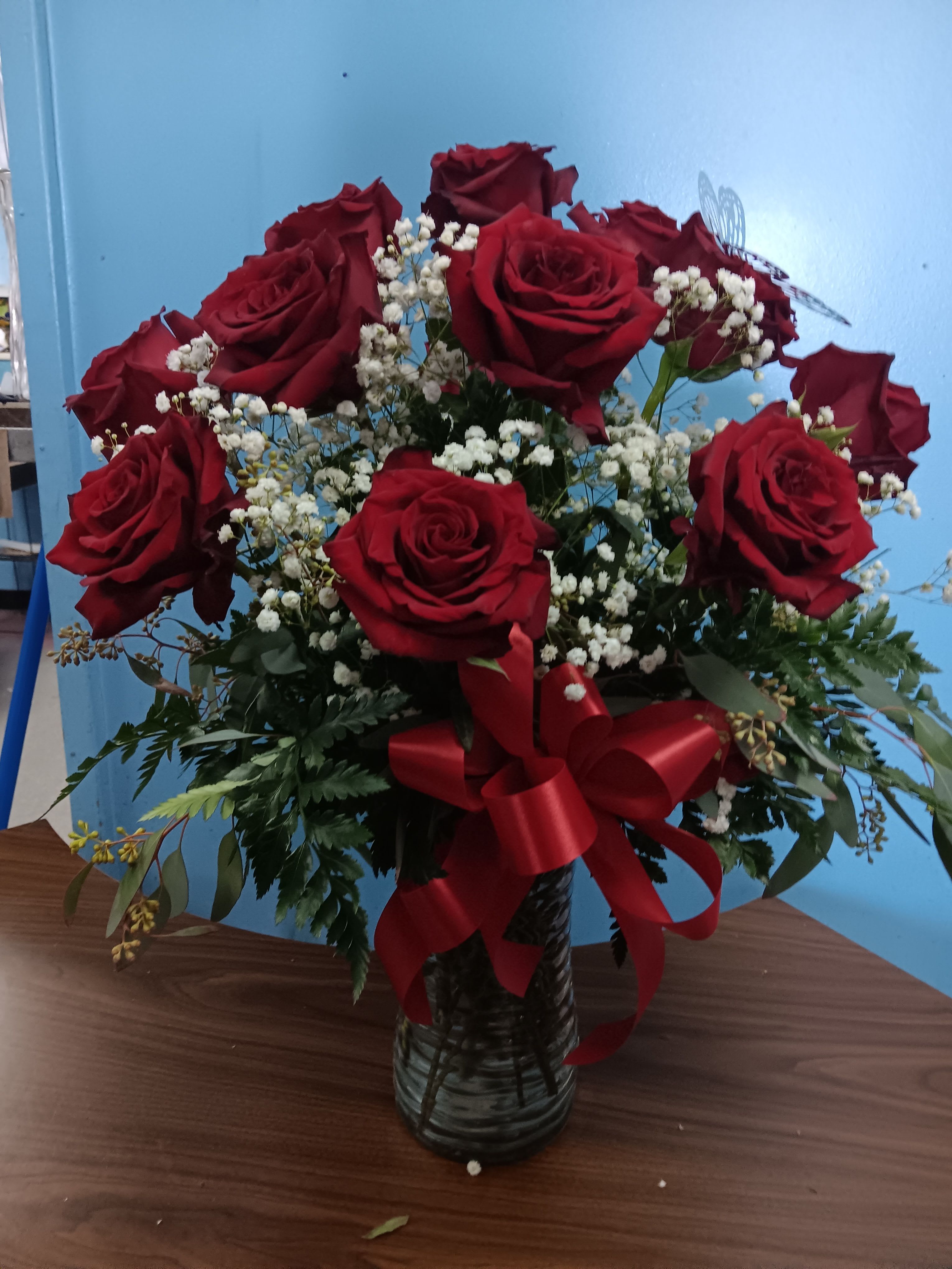 Bouquet of red roses with white baby's breath in a glass vase