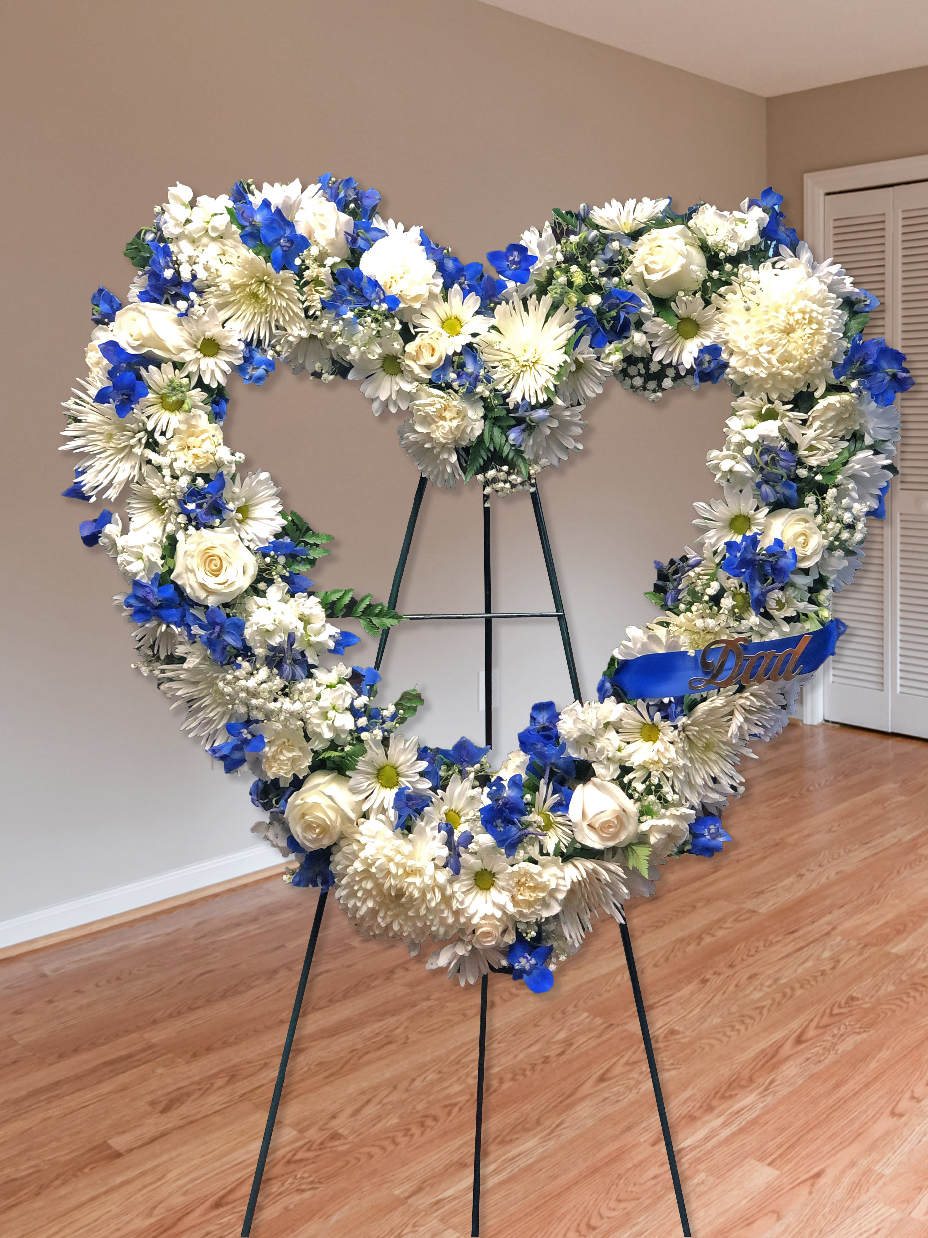 Always Remember Blue &amp; White Floral Heart Tribute - Product ID: 91239 Script can can be changed - make sure to specify. Let their special memories live on forever while expressing your deepest sympathy. This striking, heart-shaped tribute is crafted by our expert florists from fresh, beautiful blue and white blooms to help you offer your comfort and support during a difficult time. Heart-shaped arrangement of fresh blue and white flowers such as roses, delphinium, carnations and more Comes on a wire easel with accents and satin ribbon Appropriate for family or friends to send directly to the funeral home Our florists use only the freshest flowers available, so colors and varieties may vary Measures approximately 28"H x 28"L without easel