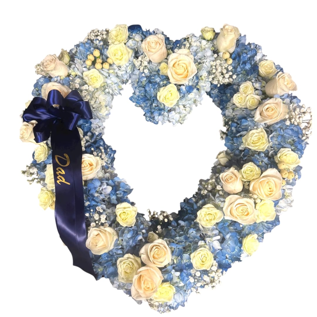 Heart-shaped floral wreath with blue and cream roses and a navy ribbon