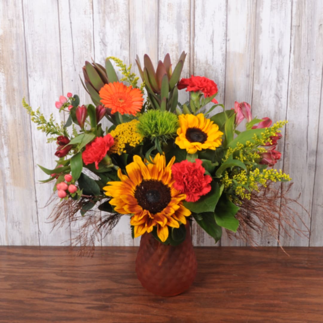 Mixed bouquet with sunflowers, gerbera daisies, and carnations in a vase