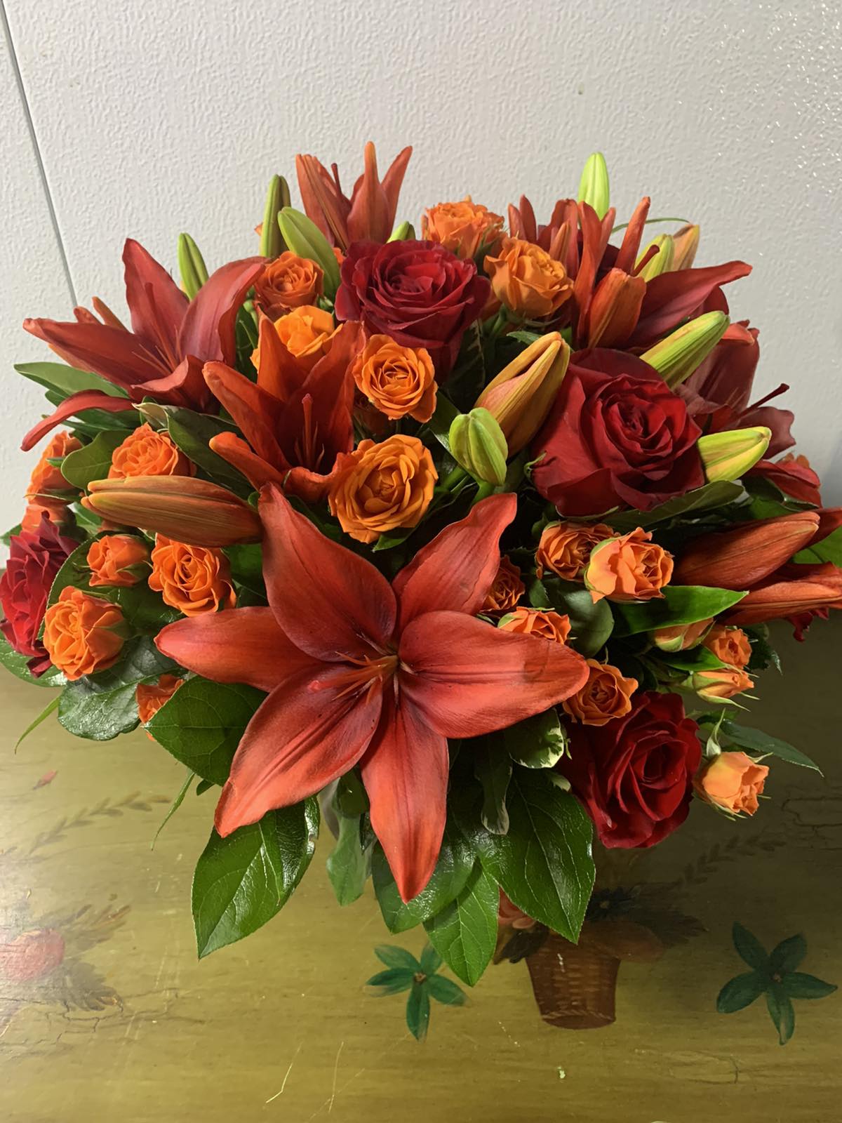 Autumn Air - An elegant gathering vase filled with seasonal bright flowers such as asiatic lilies, roses, &amp; spray roses to create a beautiful and bold sunset image.