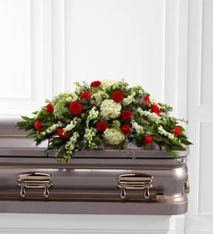 Red roses and white flowers arranged on a casket
