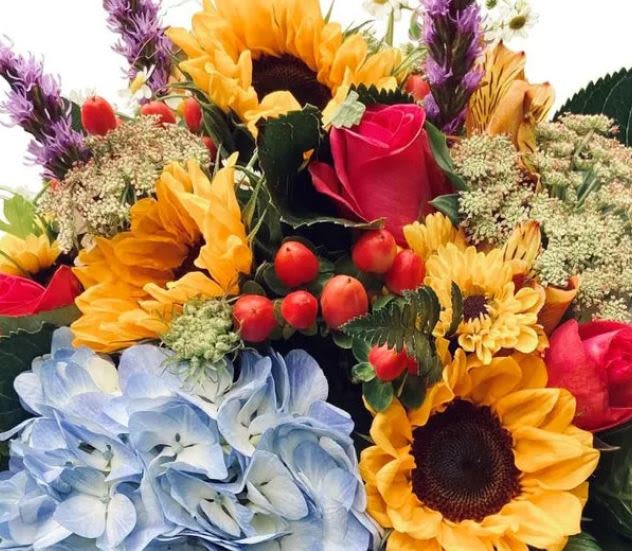 Mixed bouquet with sunflowers, roses, and blue hydrangeas