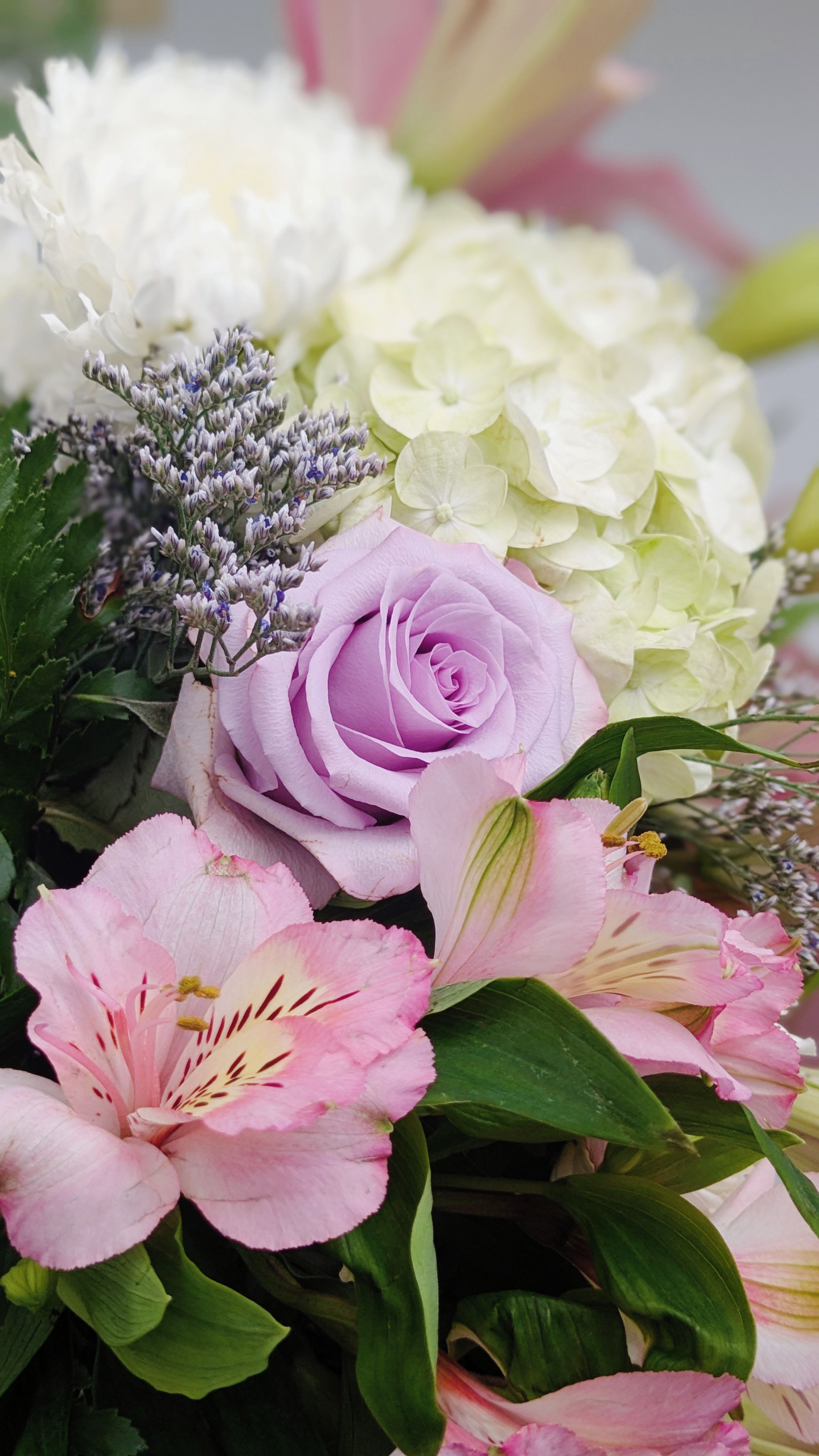 Bouquet of pink lilies, lavender rose, and white hydrangea