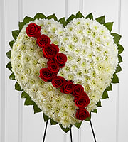 Heart-shaped white floral spray with red roses on an easel