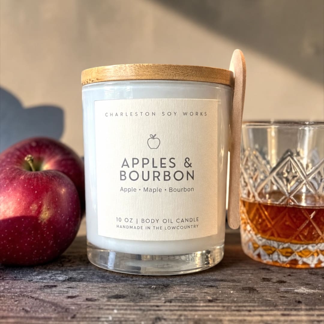 Apple-scented candle with a glass and two apples beside it