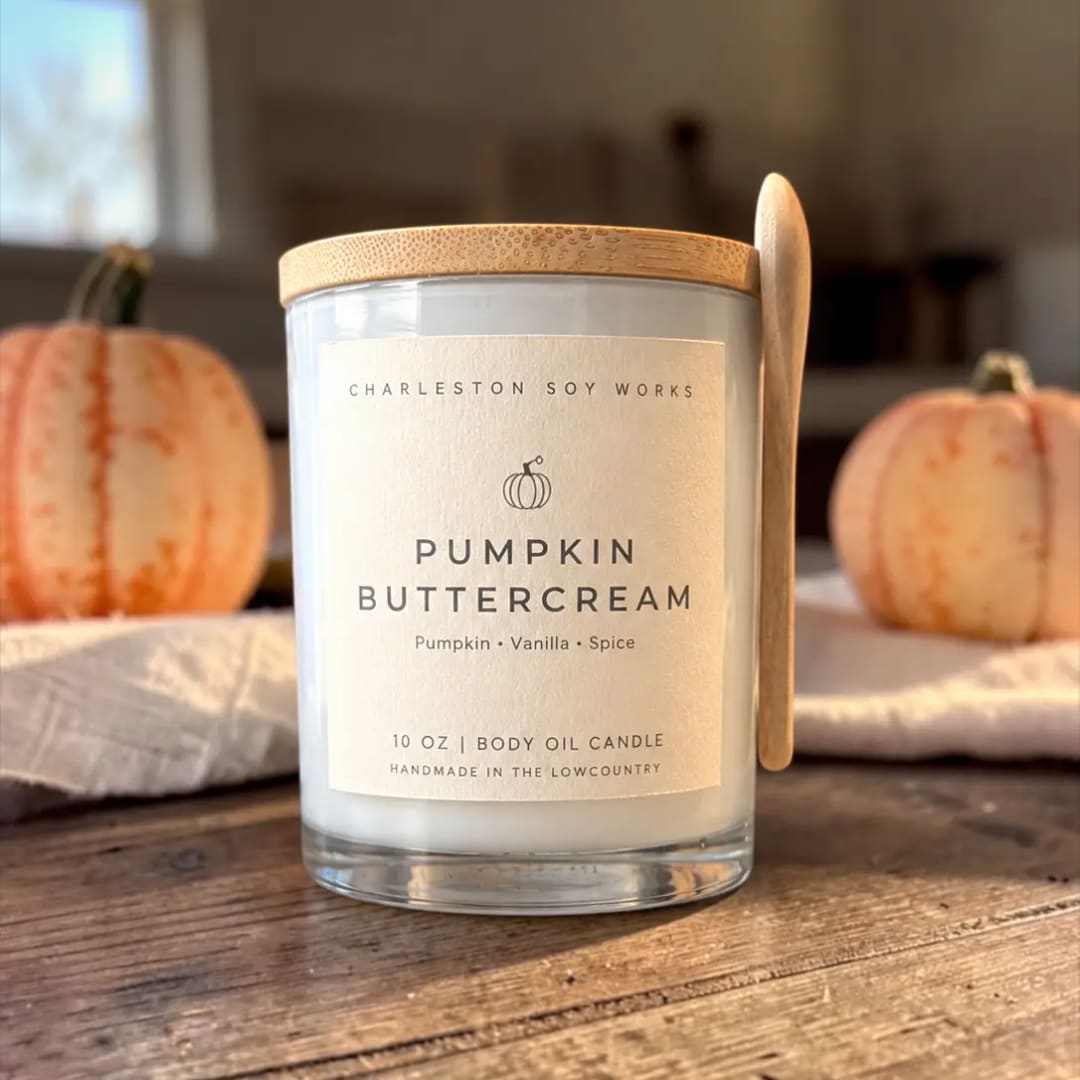 Pumpkin buttercream candle in a glass jar with a wooden lid and spoon