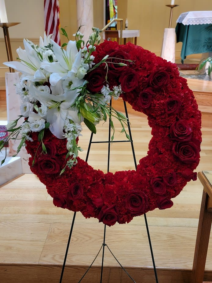 Heart-shaped red floral wreath with white lilies and roses