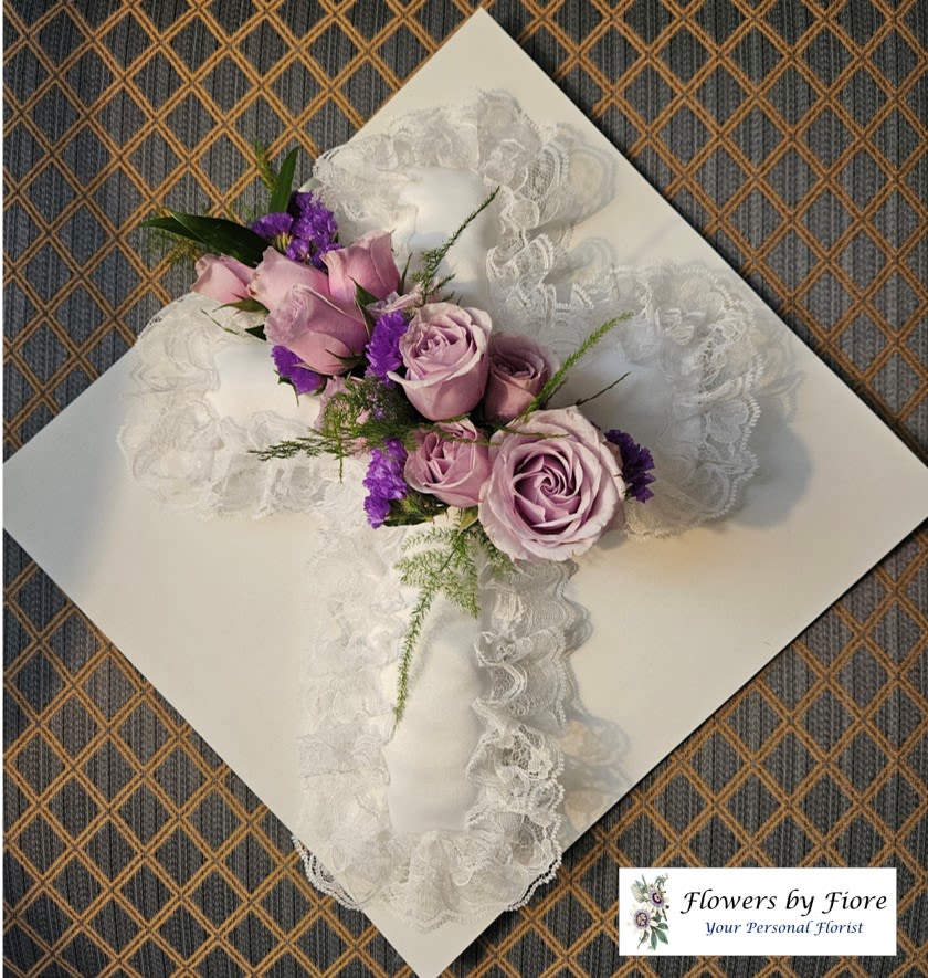 Lavender roses and purple flowers arranged on white lace ribbon