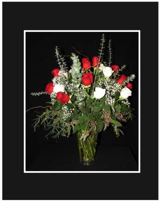 Red and white roses in a clear glass vase