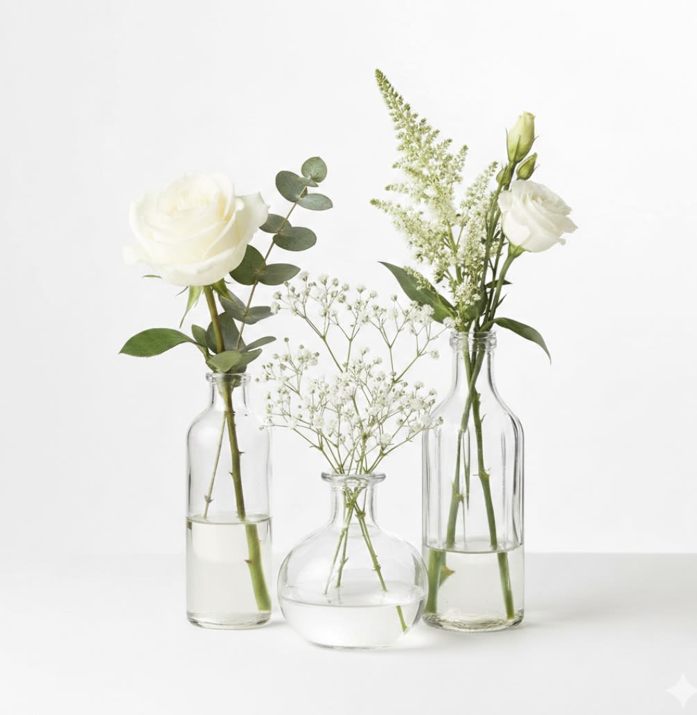 Three small glass vases with white flowers and baby’s breath