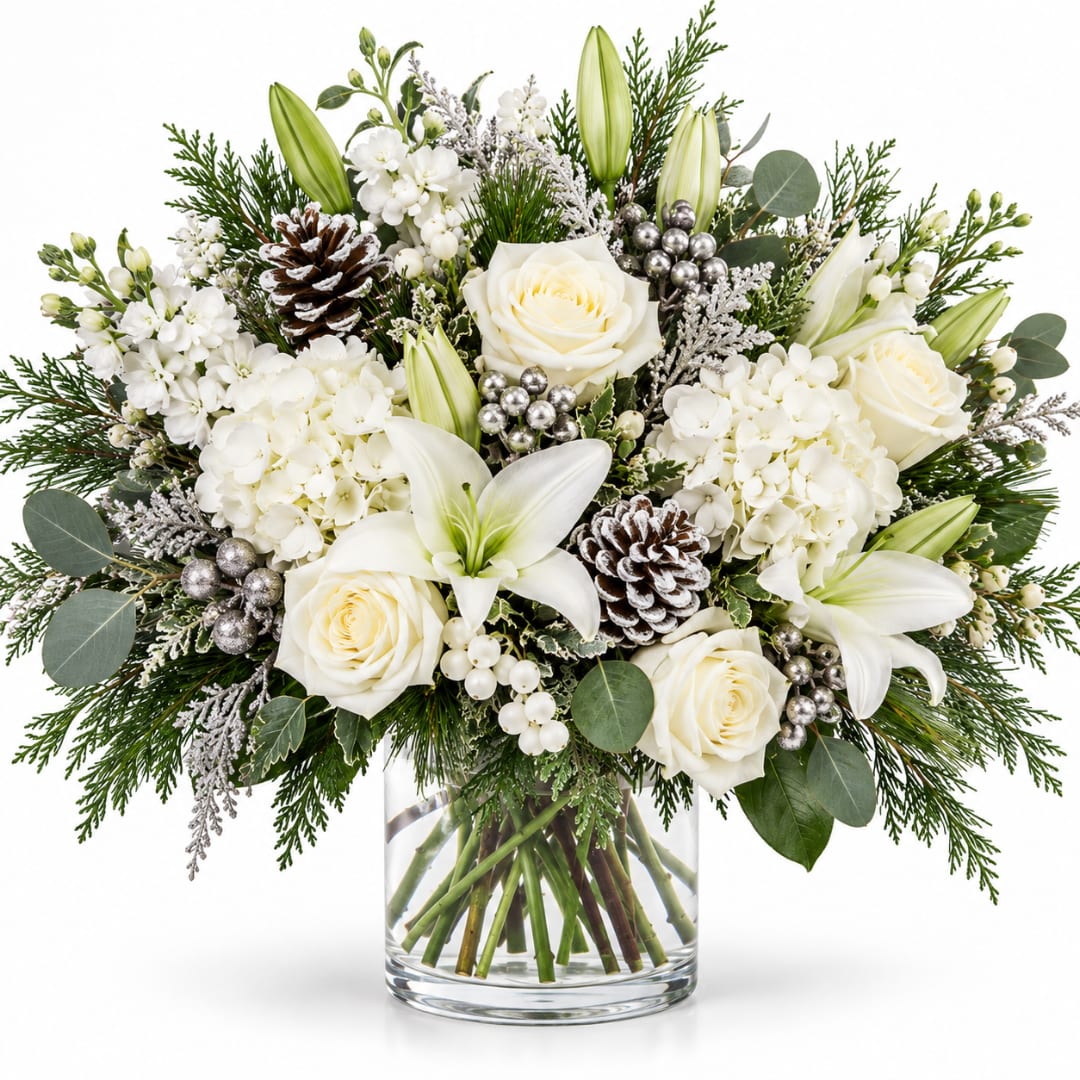 Silver Bells  - A sophisticated winter arrangement featuring white roses, lilies and hydrangeas accented with silver berries, frosted greenery and pinecones. A beautiful touch of winter elegance for any celebration or home.