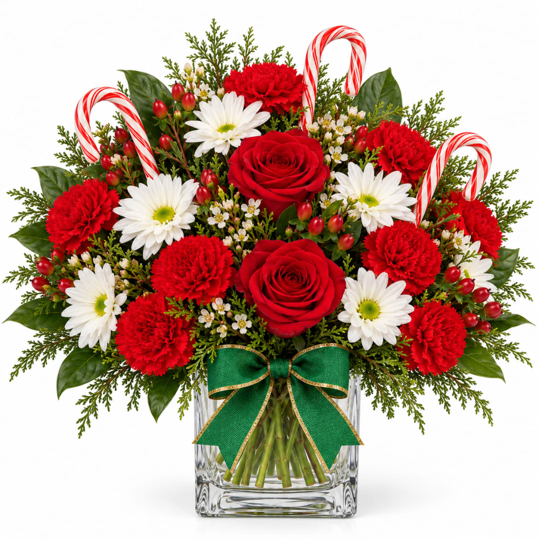 Red roses and carnations with white daisies in a glass vase with candy canes