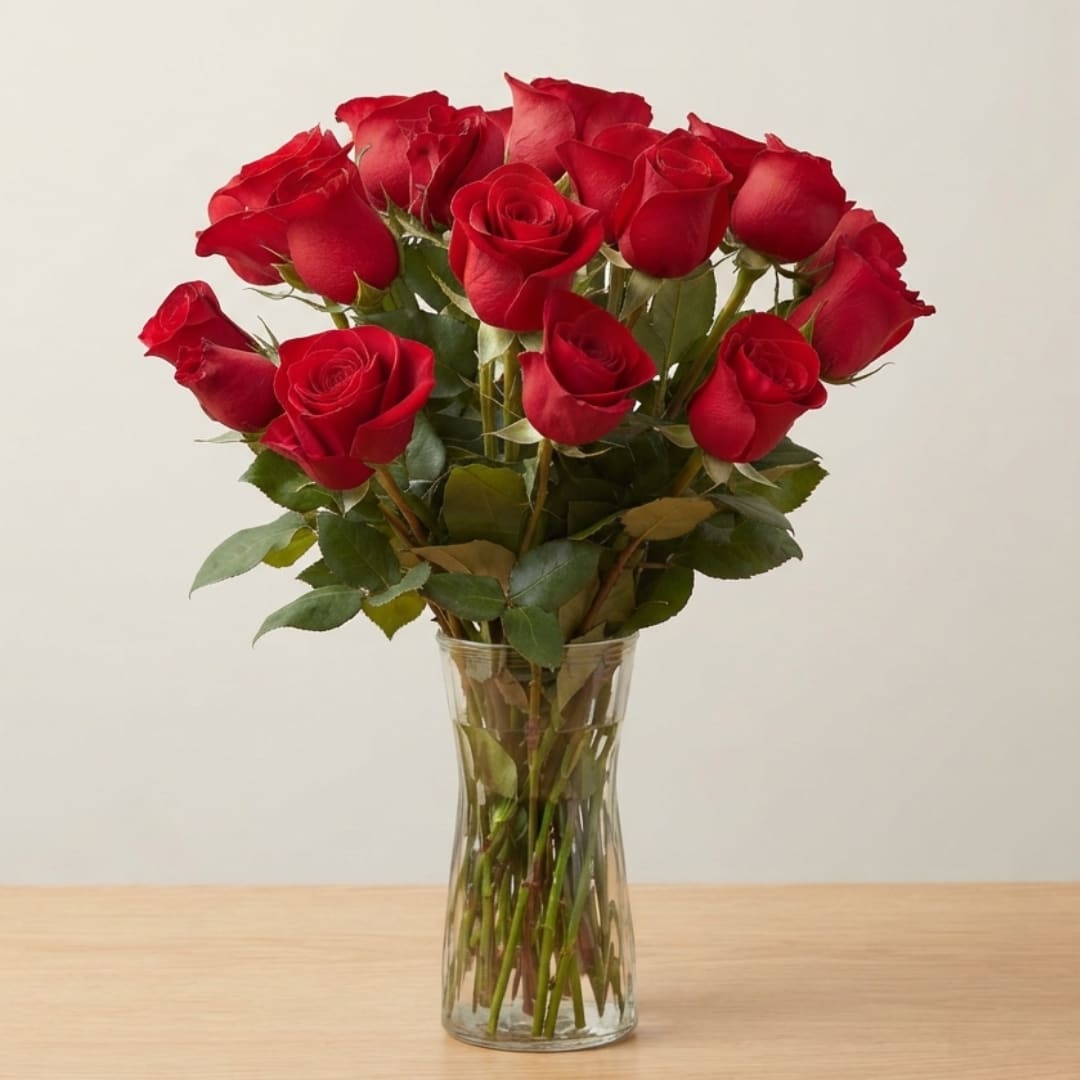 Red roses arranged in a clear glass vase