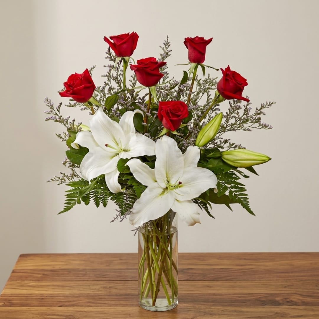 Red roses and white lilies in a clear glass vase