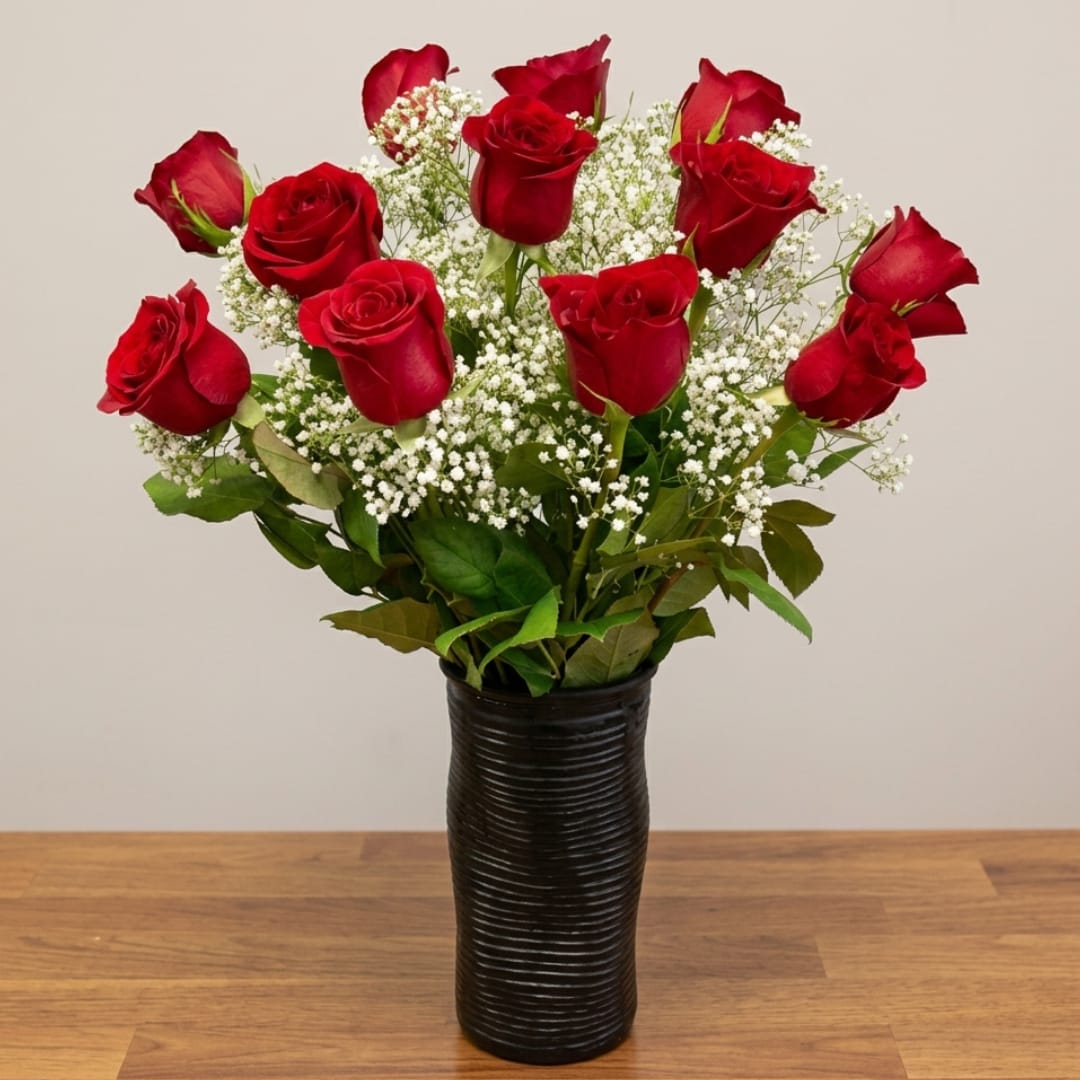 Red roses in a black vase with white filler flowers