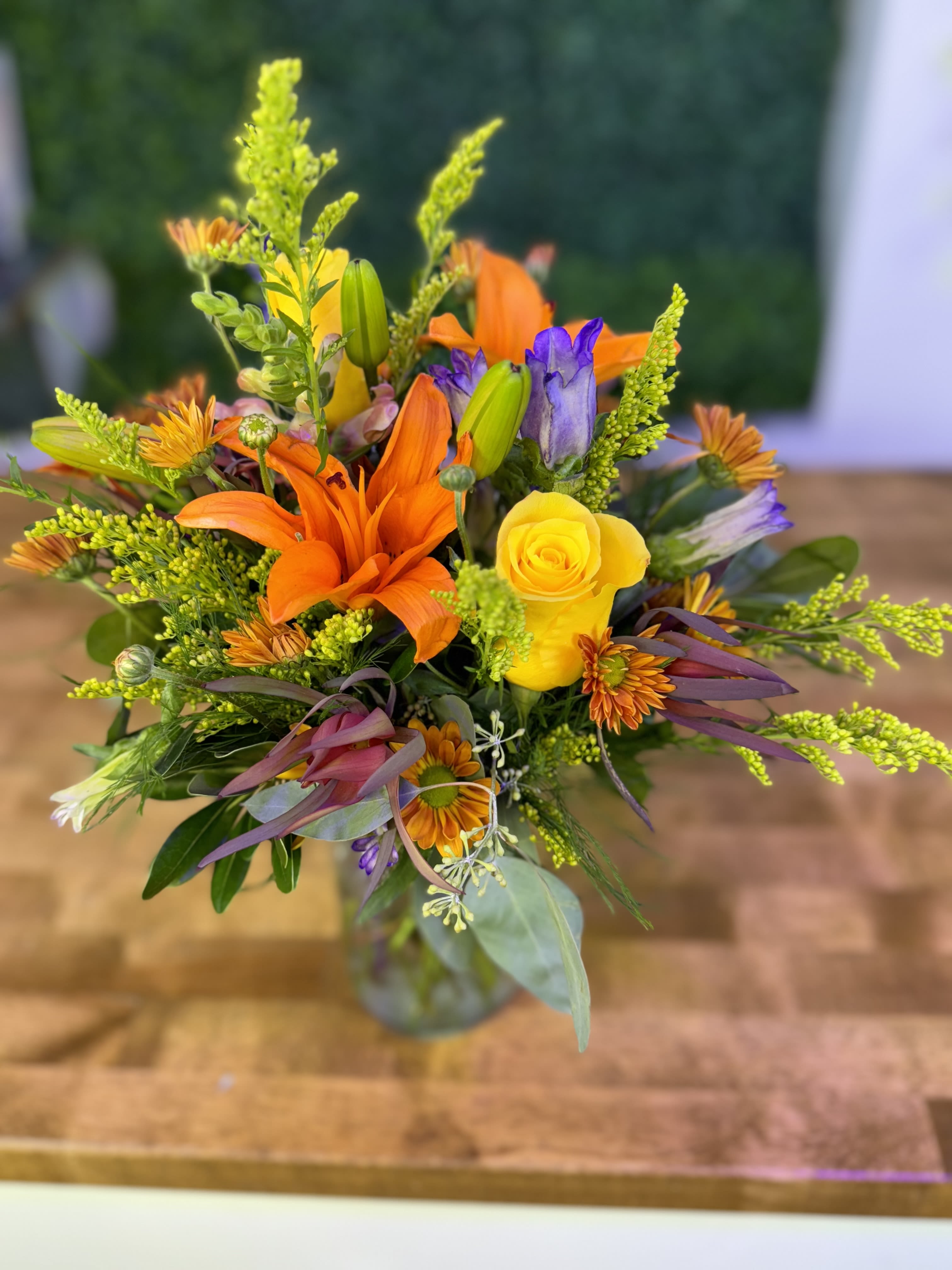 Mixed bouquet with orange lilies and yellow roses in a glass vase