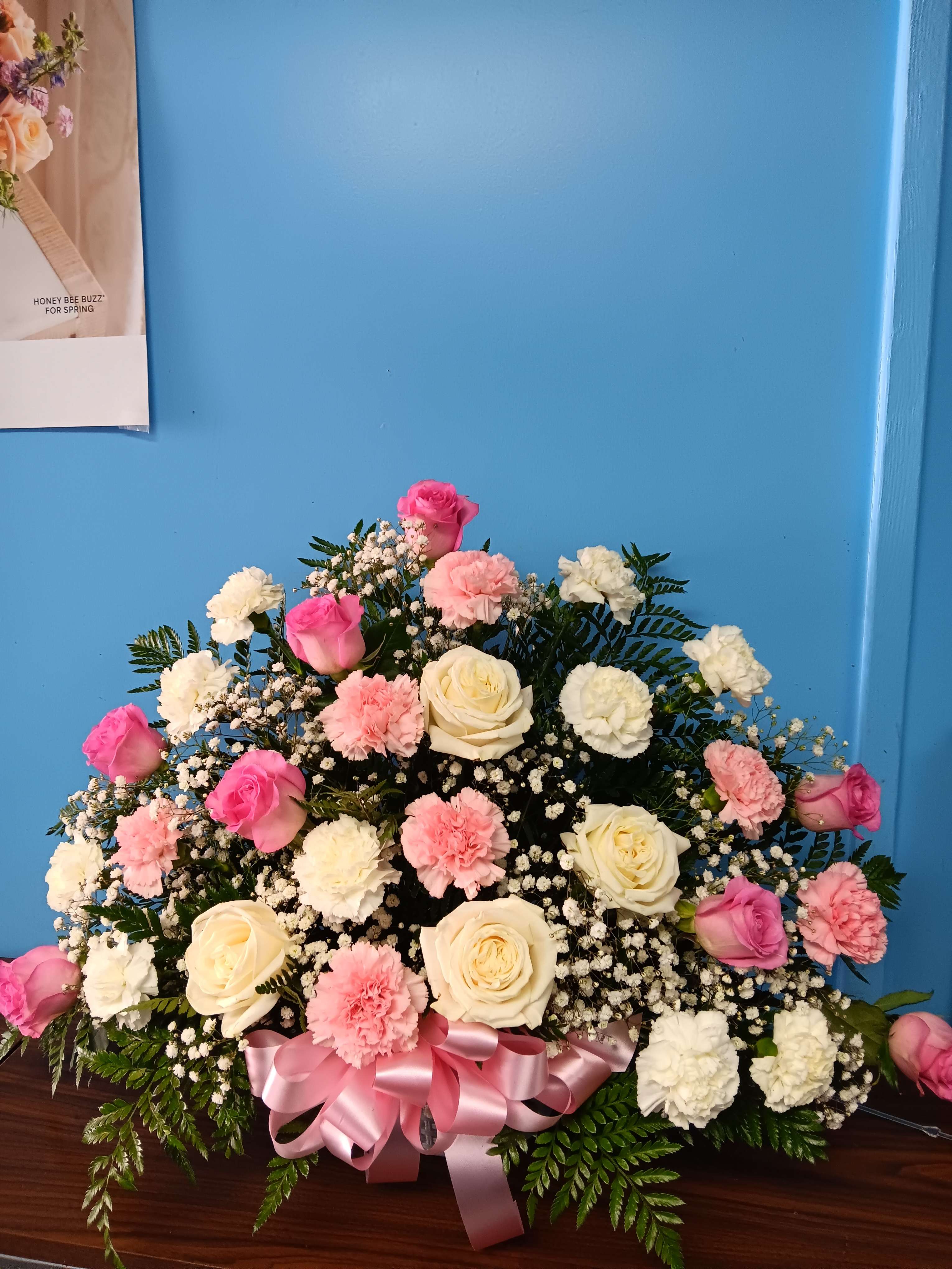 Pink and white rose and carnation arrangement with a pink ribbon