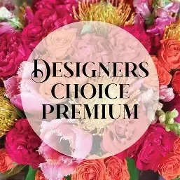 Petal Perfection's Premium Designer's Choice - A dazzling burst of hot pinks, coral oranges, and golden yellows-this premium designer's choice flower arrangement is made to make someone feel celebrated. Perfect as a birthday bouquet, anniversary surprise, or a congratulations arrangement, the dense, saturated color palette and bold textures announce joy the moment they walk in the room.  Closely clustered rounded roses sit alongside ruffled carnations and spiky protea-style blooms for high-impact contrast and a lush, full silhouette. The mix of pink, orange, red and yellow blooms creates energetic visual movement and a tactile mix of soft petals and sculptural spikes, crafted by our florist rather than a fixed recipe so each delivery is uniquely arranged.  Send this when you want the recipient to feel truly seen-vibrant, uplifted, and celebrated. Because it's a designer-created premium mix, sizes may vary slightly; ask about vase or delivery options at checkout for care and sizing details to ensure the perfect presentation.