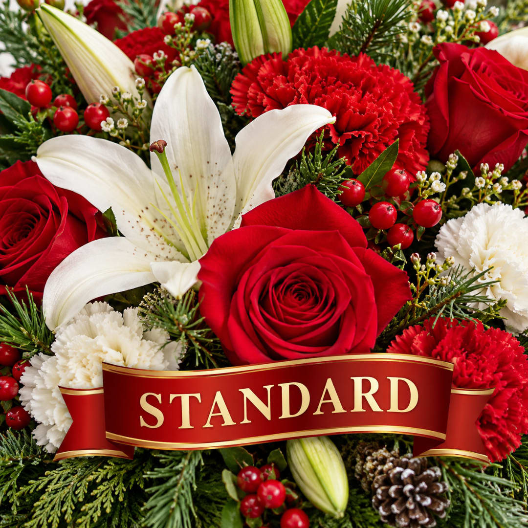 Red roses, white lilies, and carnations in a holiday arrangement with a STANDARD ribbon