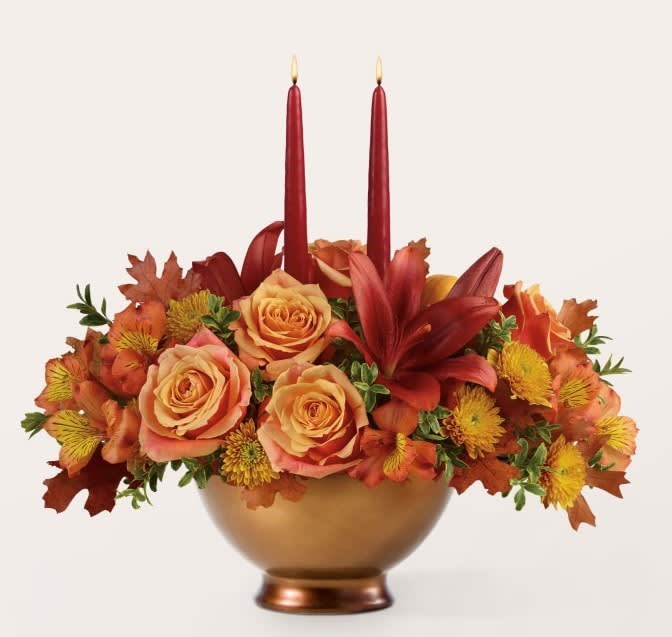 Autumn floral centerpiece with red candles in a gold bowl vase
