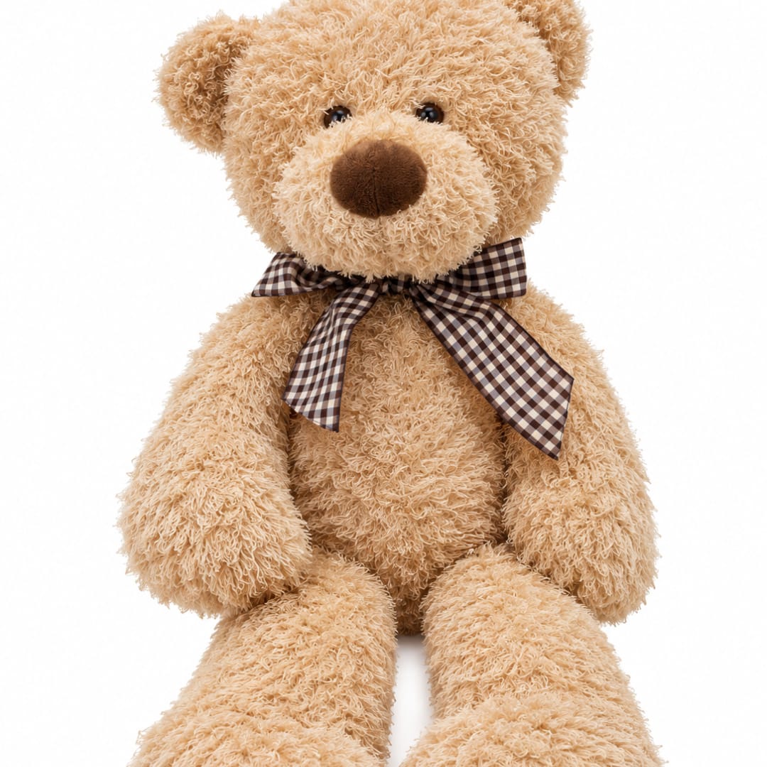 Tan teddy bear with a checkered ribbon bow