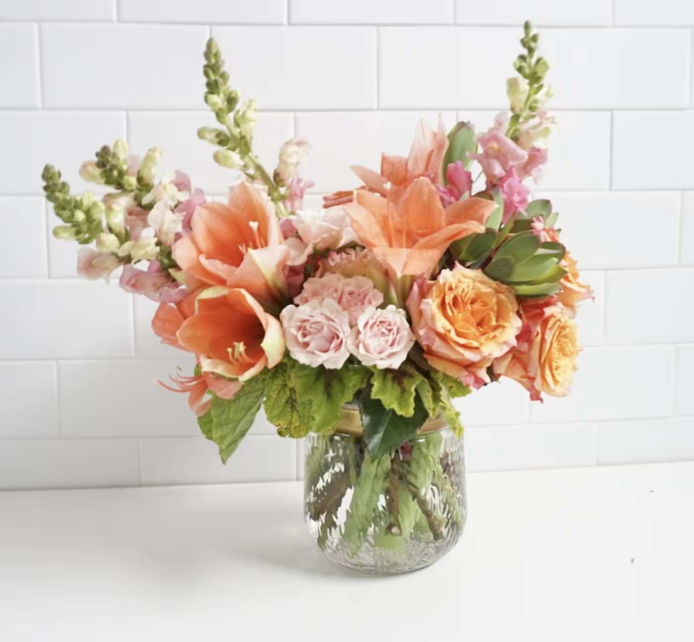 Peach and pink floral arrangement in a clear glass vase
