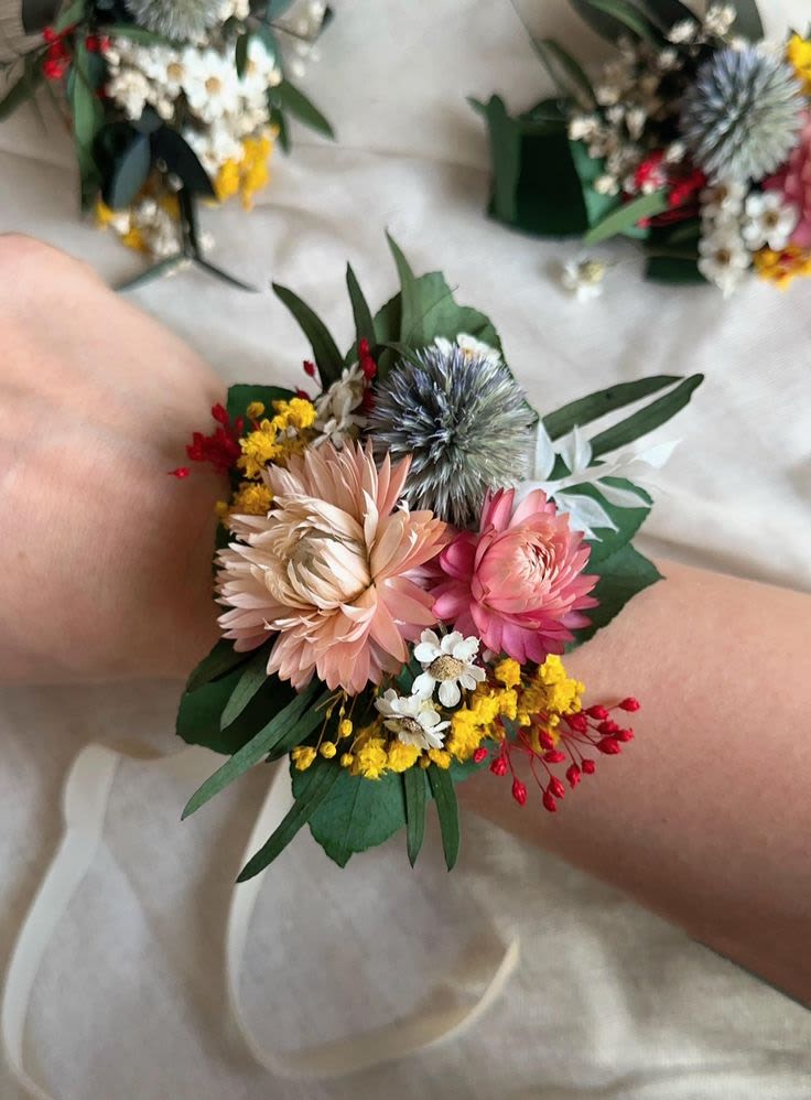 Floral wrist corsage with pink and peach blooms and small yellow accents