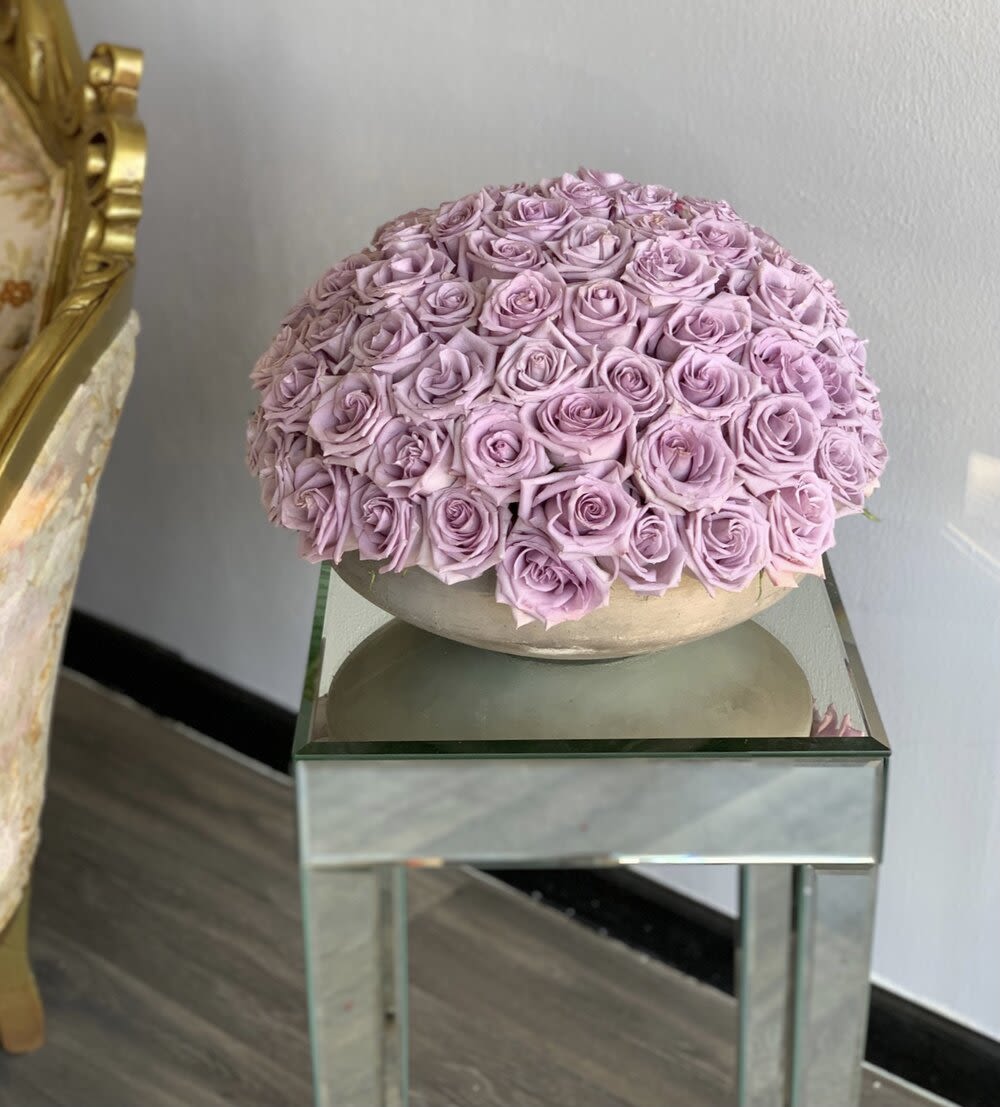 Round arrangement of lavender roses in a low bowl