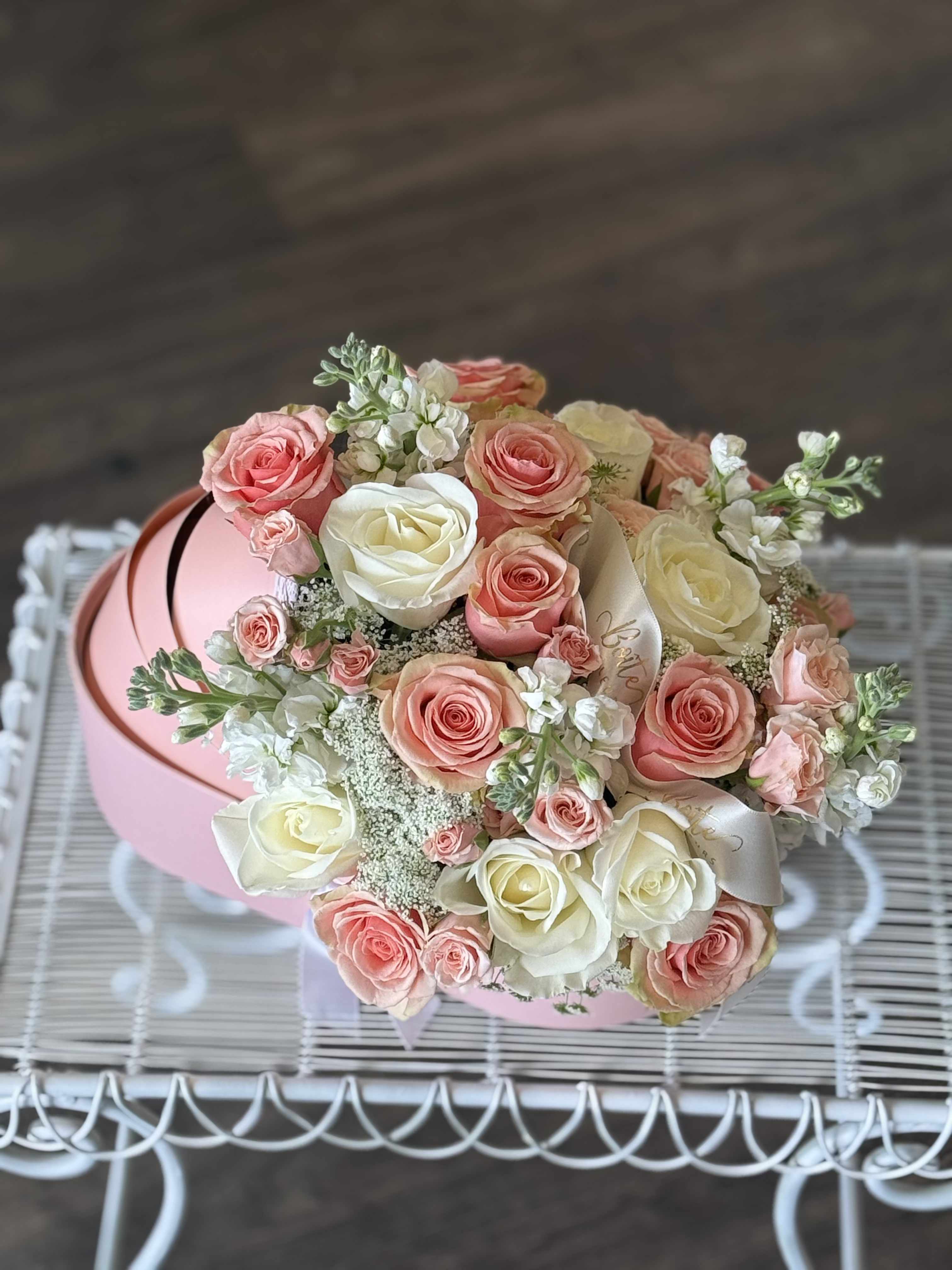Bouquet of pink and white roses in a round pink box