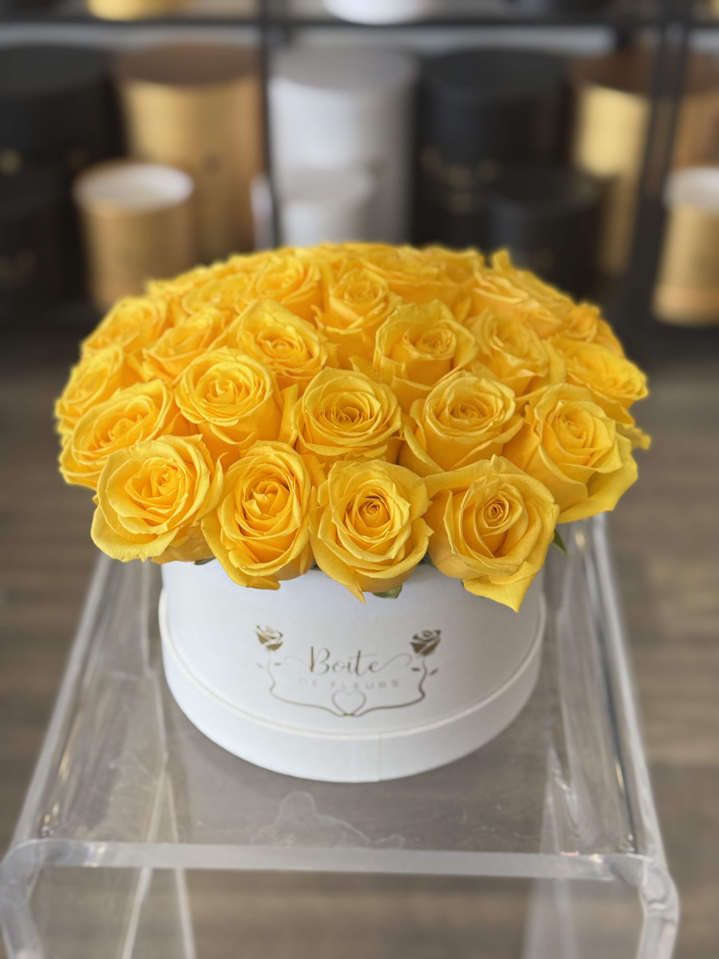 Yellow roses arranged in a white round box