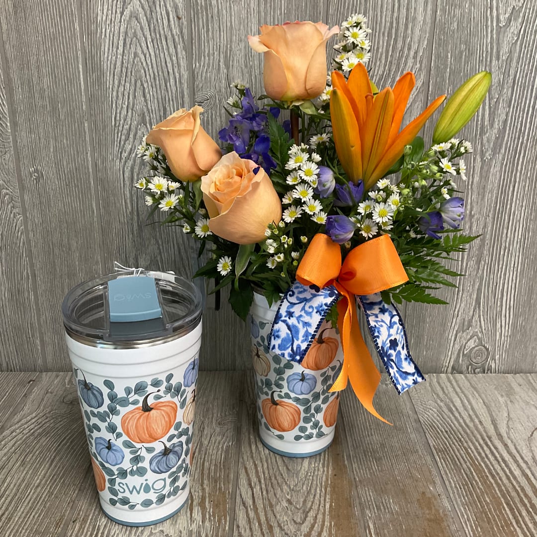Peach roses and orange lilies in a pumpkin-patterned tumbler with ribbon