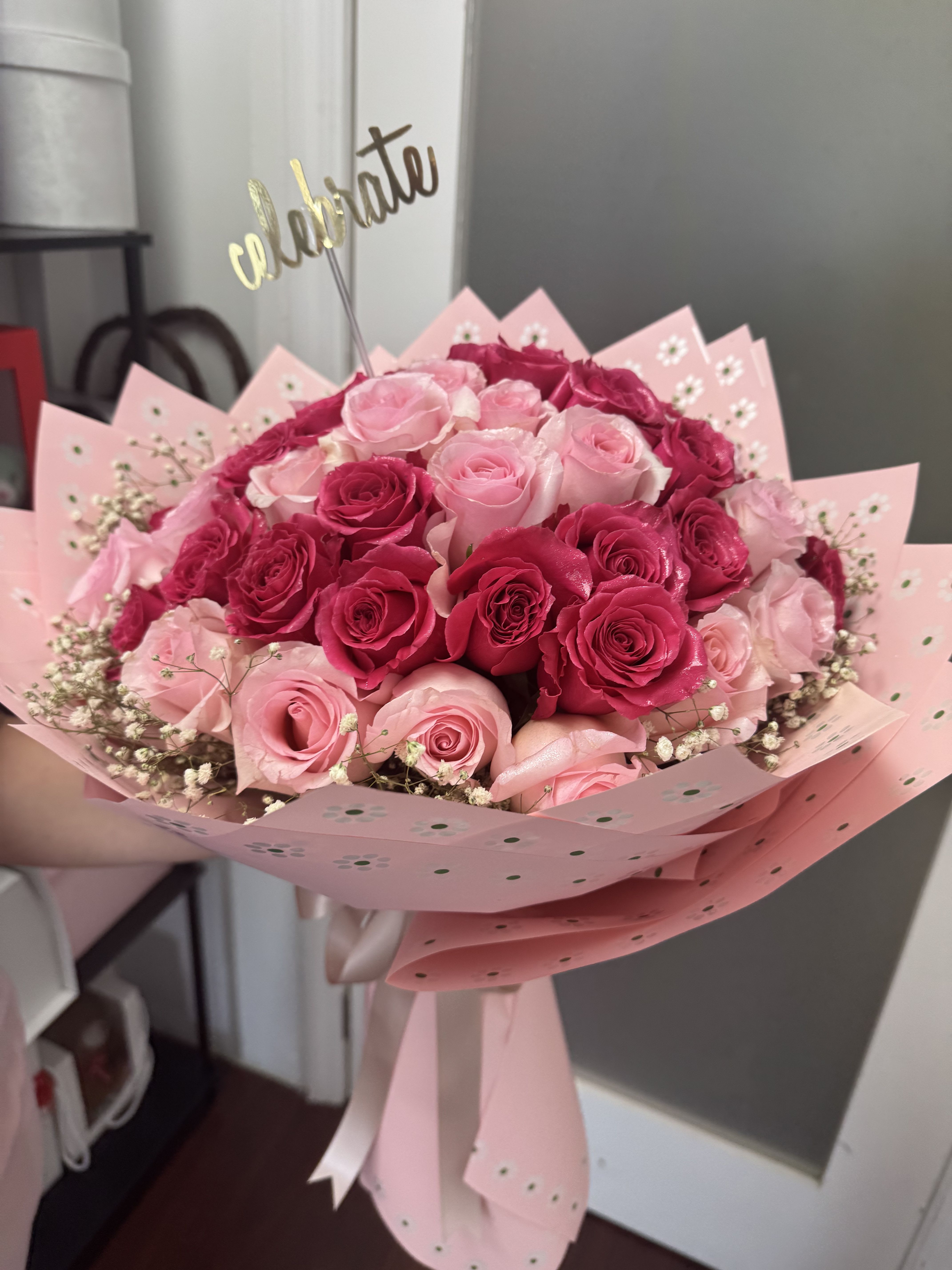 Bouquet of pink and hot pink roses wrapped in pink paper