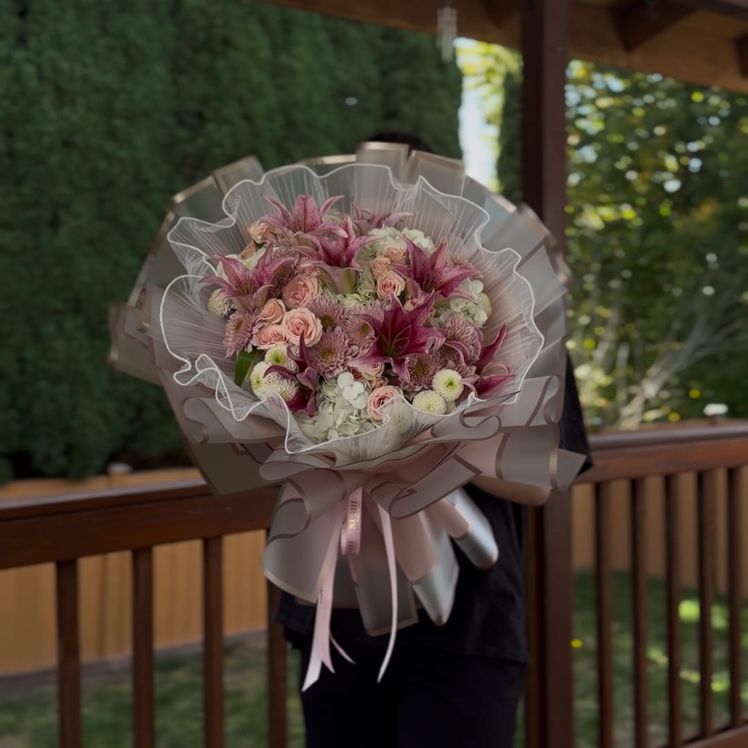 Large pink and white bouquet wrapped in translucent paper