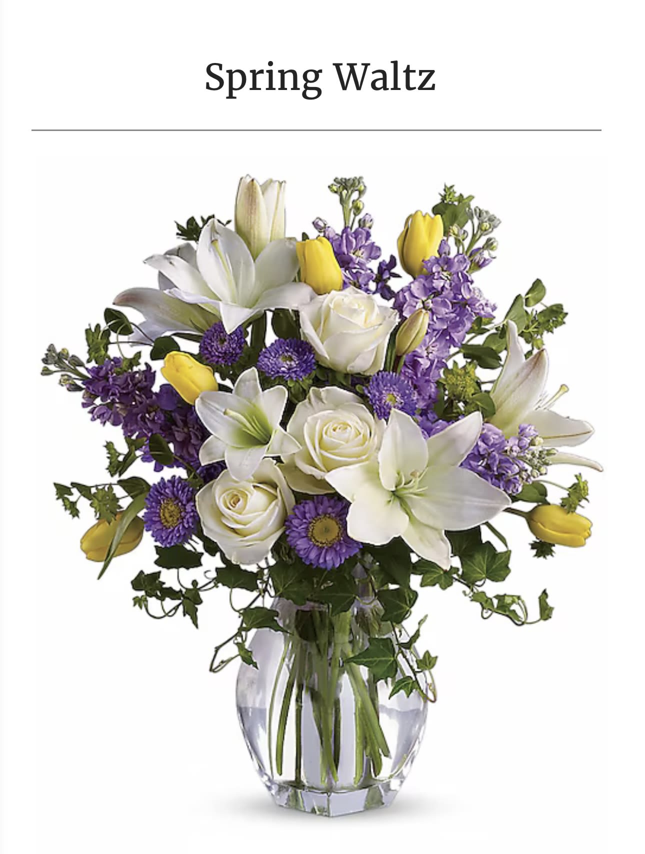 White lilies, roses, and purple flowers in a clear glass vase