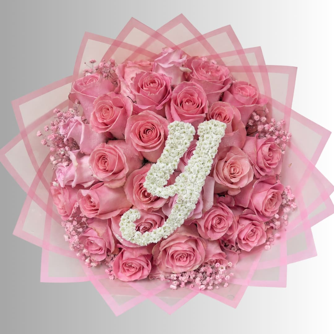 Pink rose bouquet with white floral initials on pink wrap