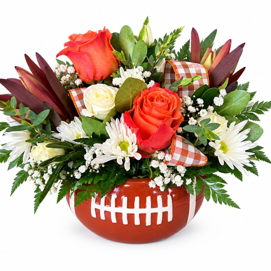 Football-shaped vase with roses and white daisies