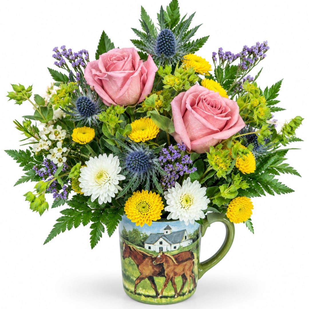 Pink roses and mixed flowers arranged in a painted mug vase