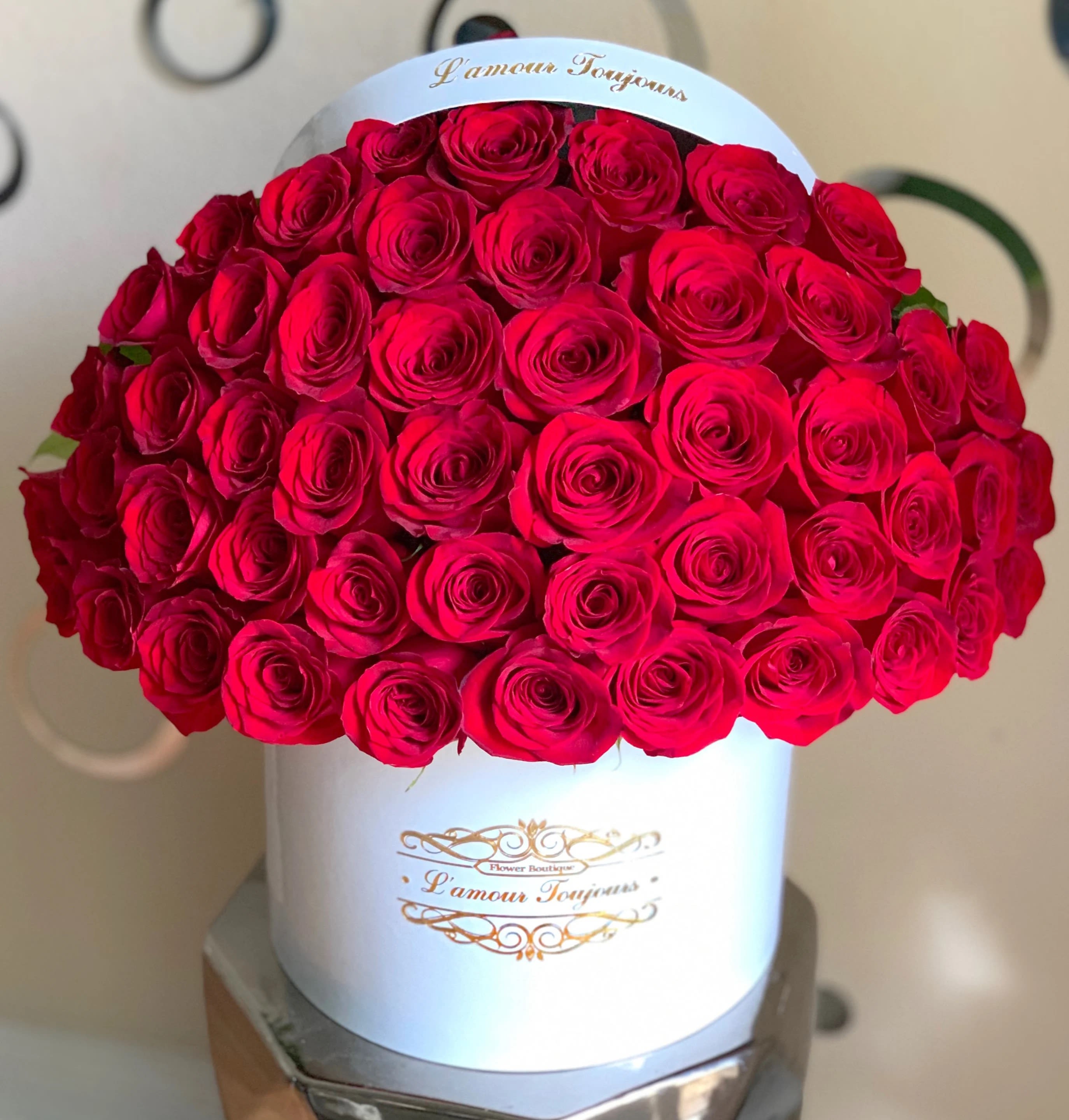Large bouquet of red roses in a white hatbox
