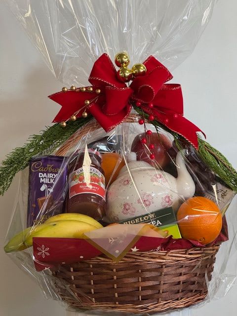 Gift basket with fruit, tea, chocolate, and a teapot wrapped in clear cellophane