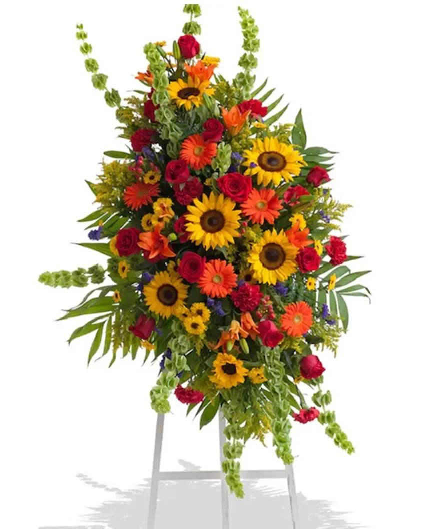 Large standing floral spray with sunflowers, red roses, and orange blooms