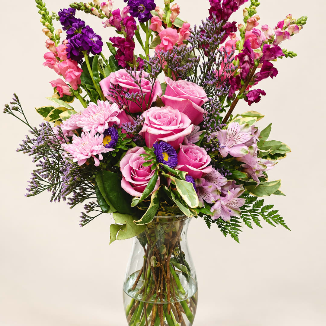 Pink and purple mixed bouquet in a clear glass vase