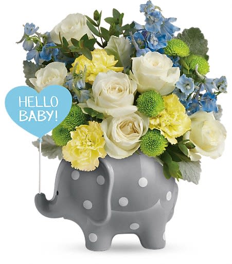 Bouquet of white, yellow, and blue flowers in a gray elephant vase with a baby sign
