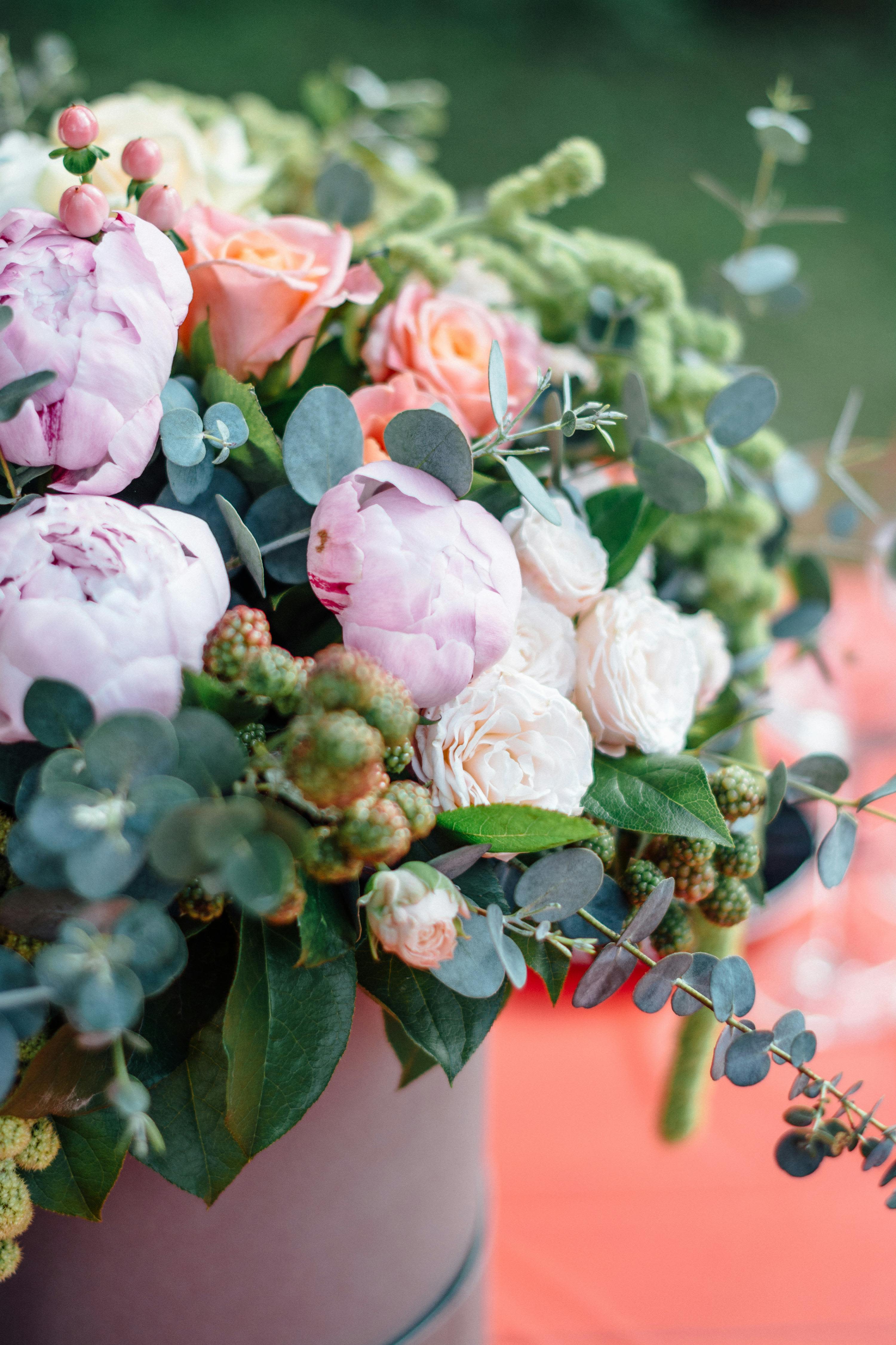Pink and peach roses with pale peonies in a vase