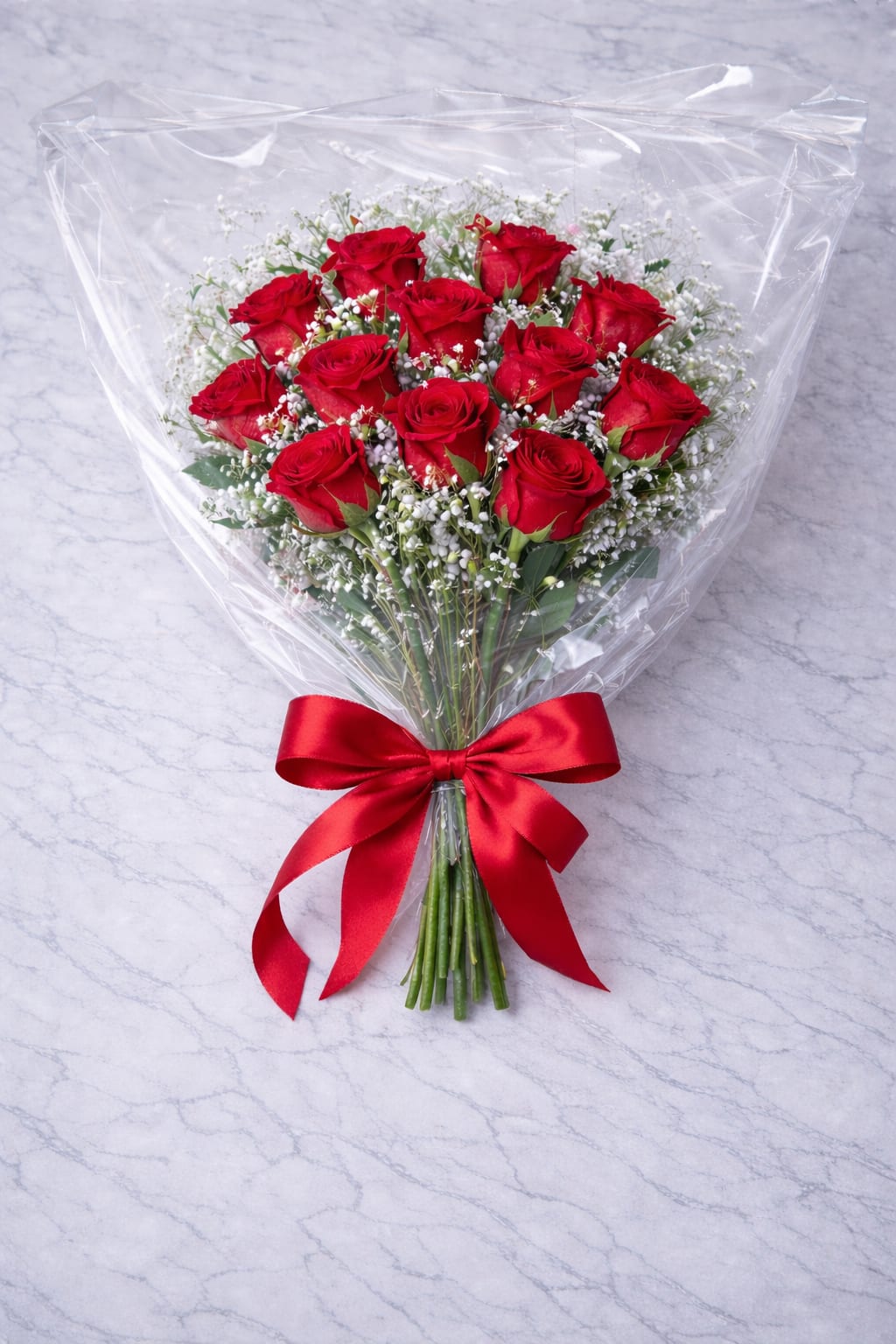 Bouquet of red roses wrapped in clear plastic with a red ribbon