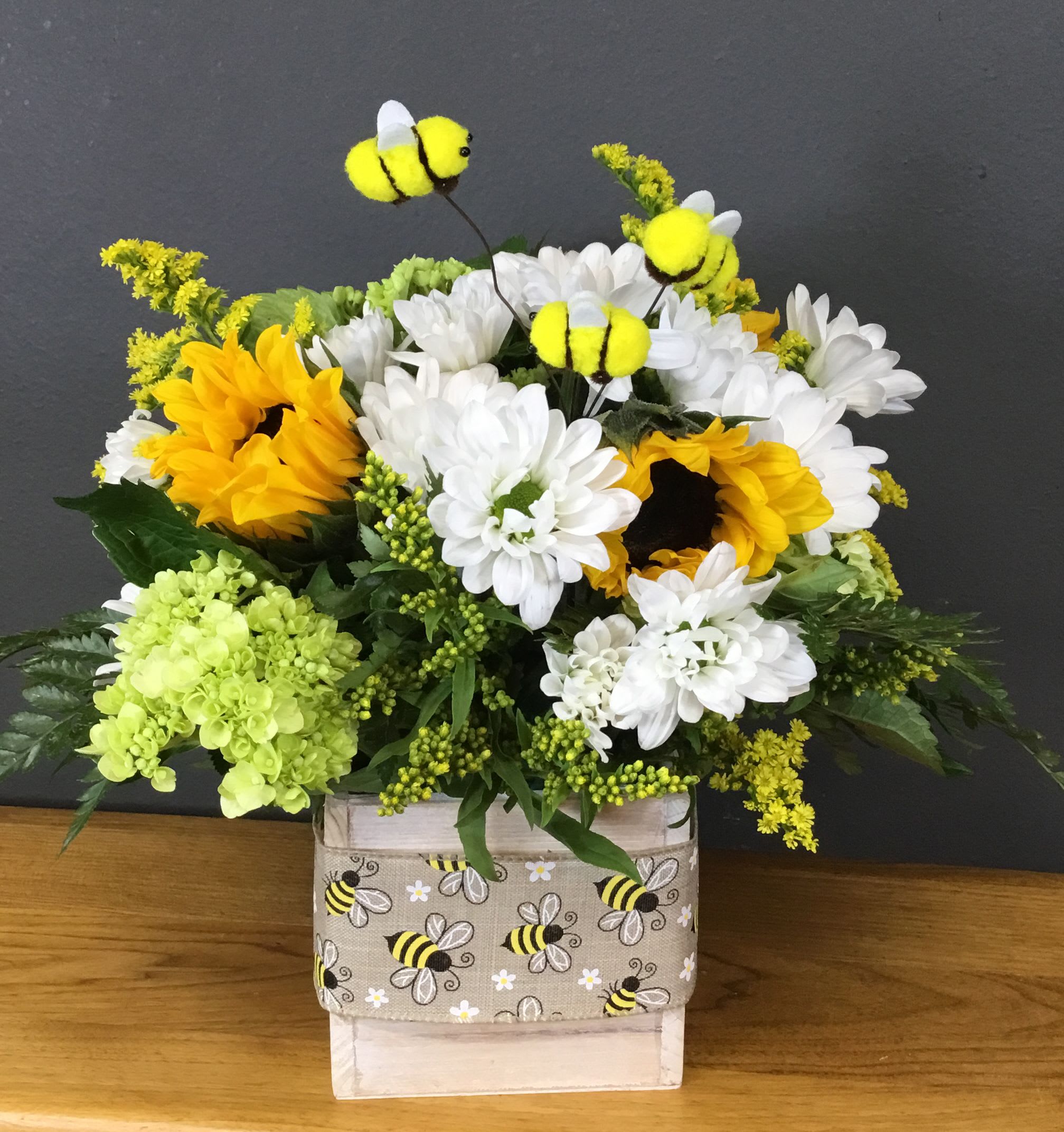 Bee Kind Bouquet - Golden sunflowers and lavender roses create an instant smile in this Bee Kind bouquet-perfect as a Mother's Day gift or a cheerful pick-me-up for birthdays, get well wishes, or just because. The arrangement reads bright and summery, so it also suits graduations, housewarmings, Memorial Day or Labor Day barbecues, and any moment you want the person you're thinking of to feel noticed and lighthearted.