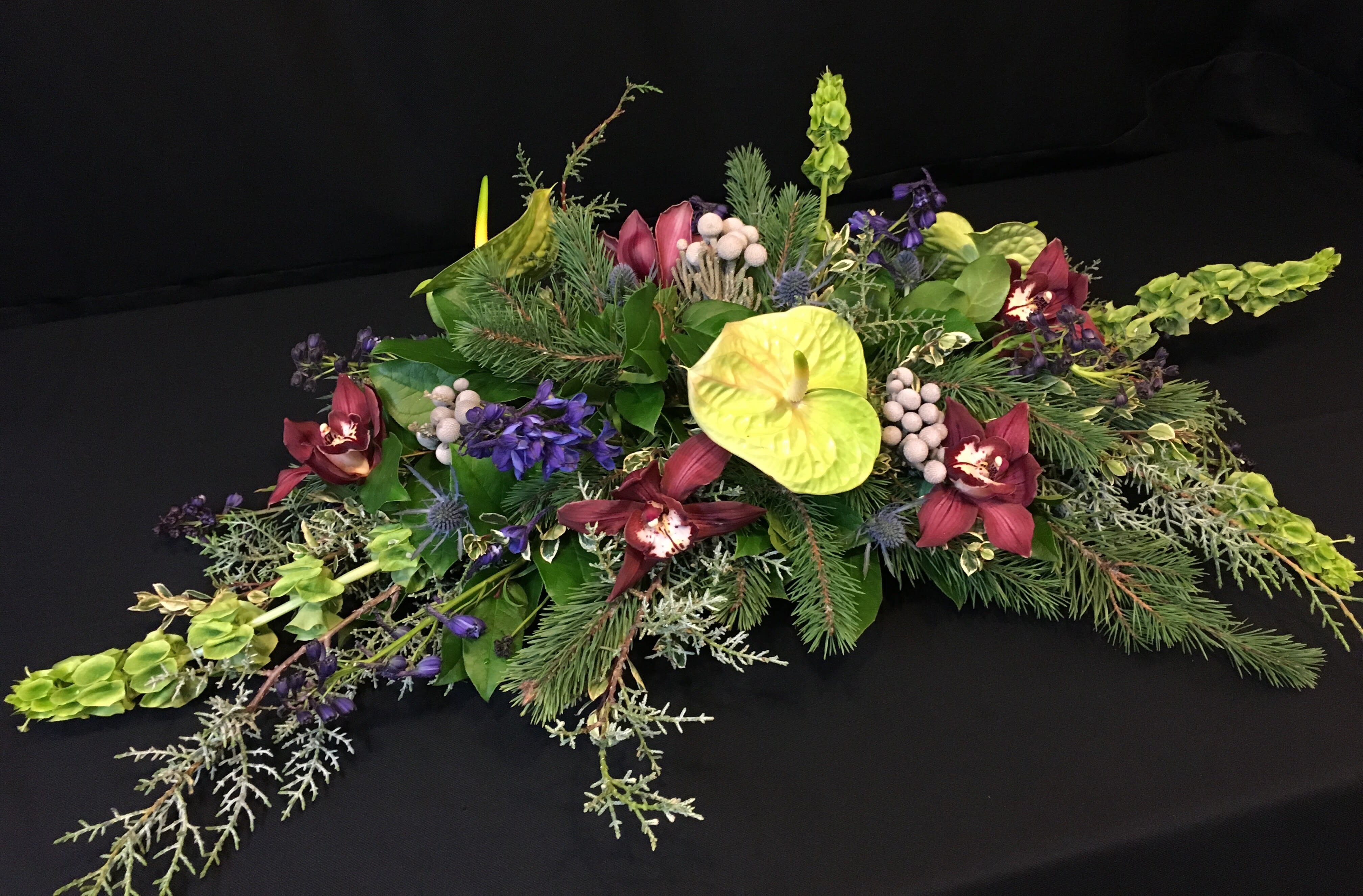 Winter long exotic centerpiece blue &amp; green - Dramatic long low event centerpiece or for your holiday dinner table.  Let us know your colors in advance so we can customize for you.  Premium exotic flowers like orchids, bells of Ireland, anthurium and brazelia baubles.  