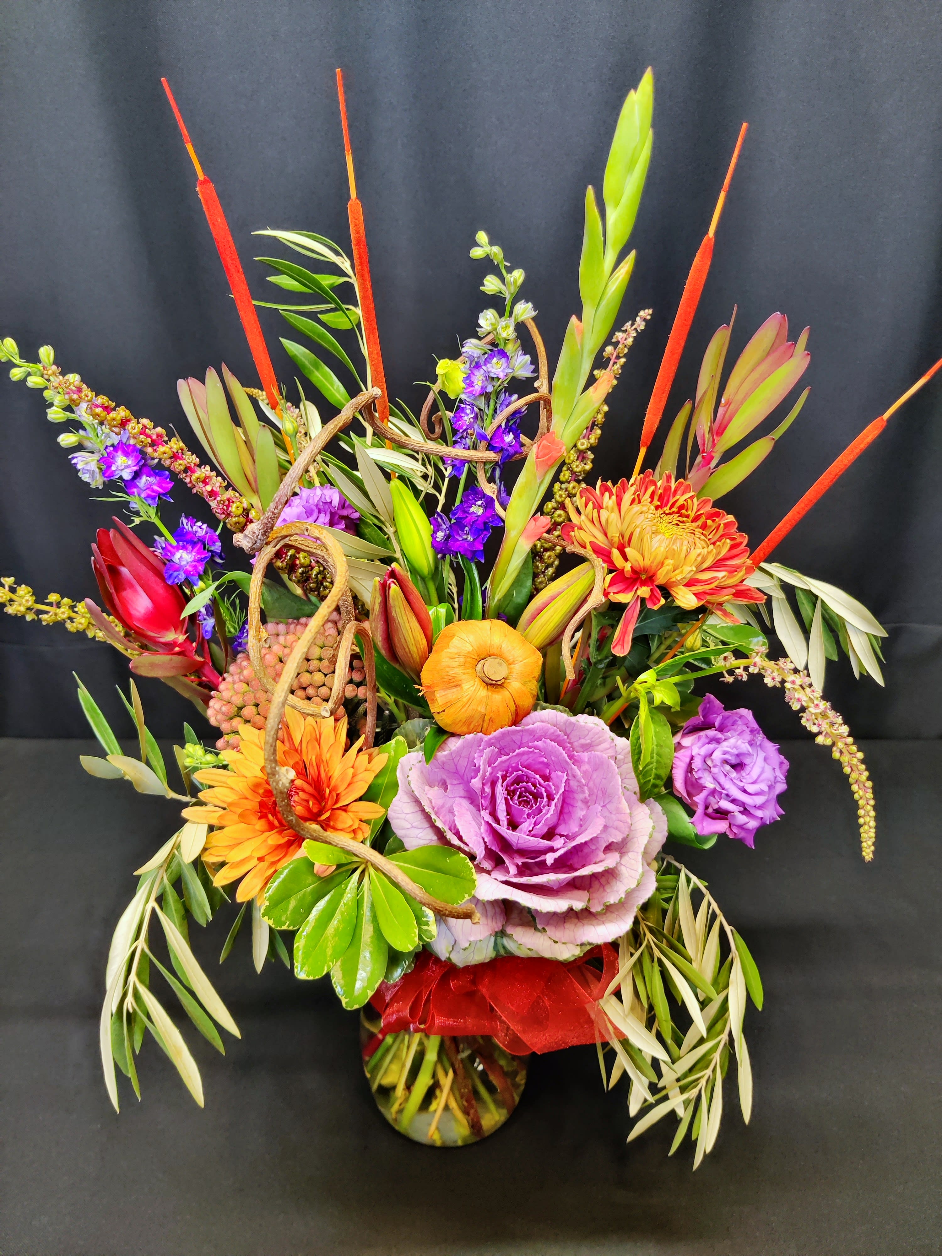 Glorious fall kale bouquet - Splashing fun fall color! Dynamic array of hues and accents.  Assortment will vary but will include the cattails and kale as long as you order a week ahead as we always suggest.