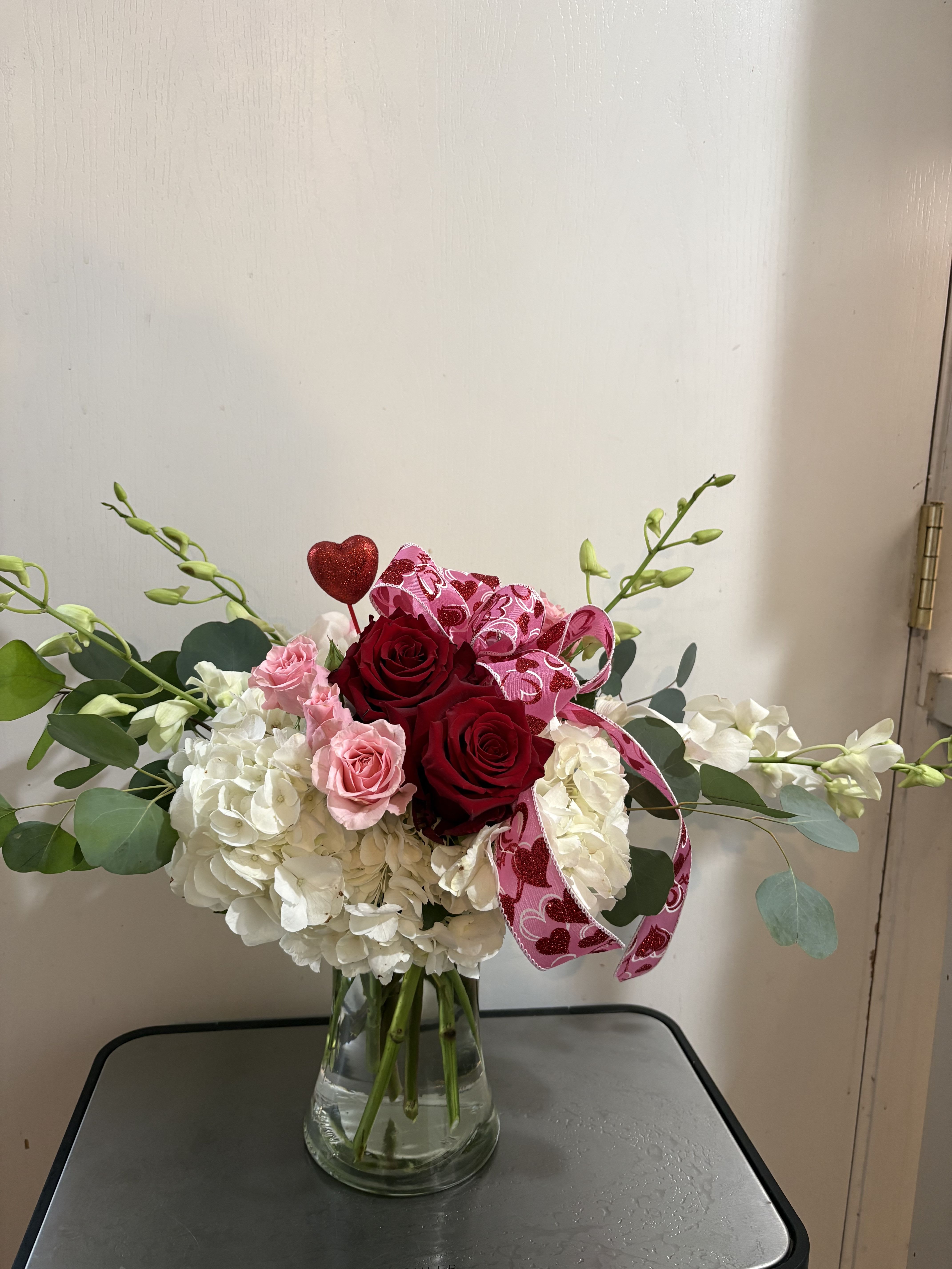 Love is in season - Hydrangea, roses and dendrobium orchids adorned with ribbon. 