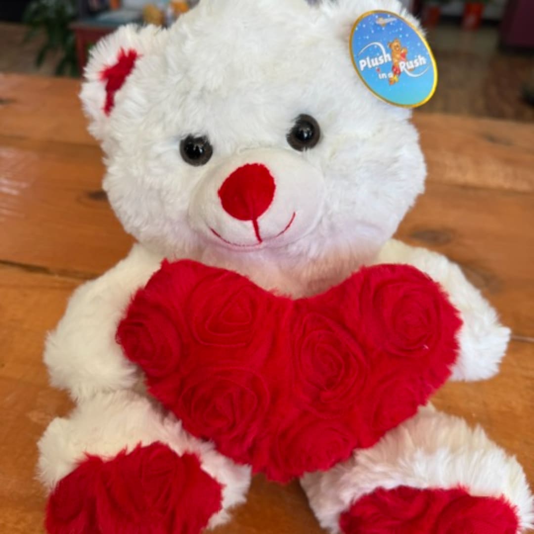 White teddy bear holding a red heart
